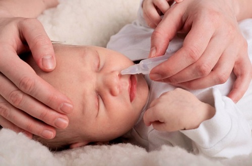 Dùng nước muối sinh lý và dụng cụ hút mũi chữa sổ mũi ở trẻ sơ sinh